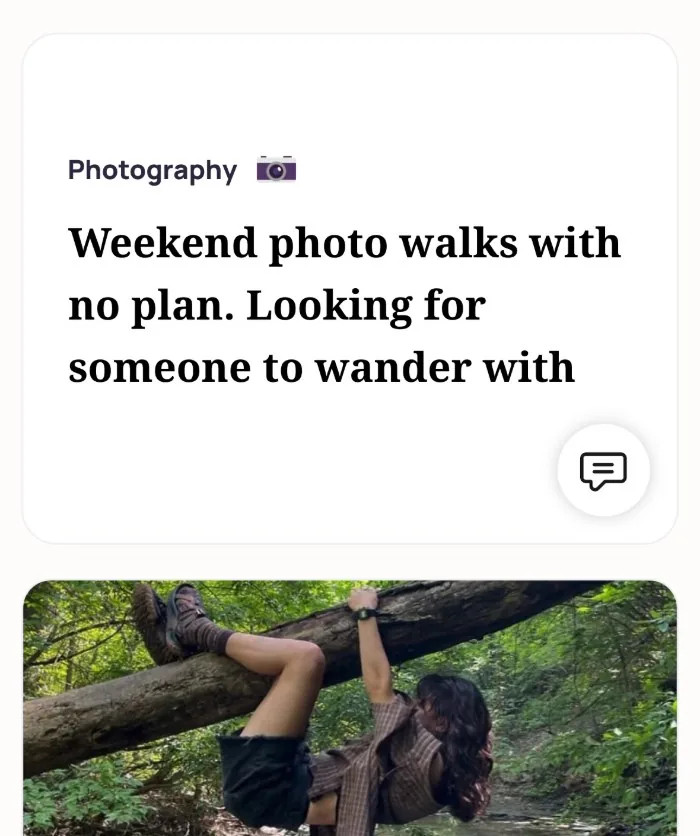An Alyke profile card for Photography that reads: Weekend photo walks with no plan. Looking for someone to wander with, above a photo of the member hanging off a fallen tree in a forest