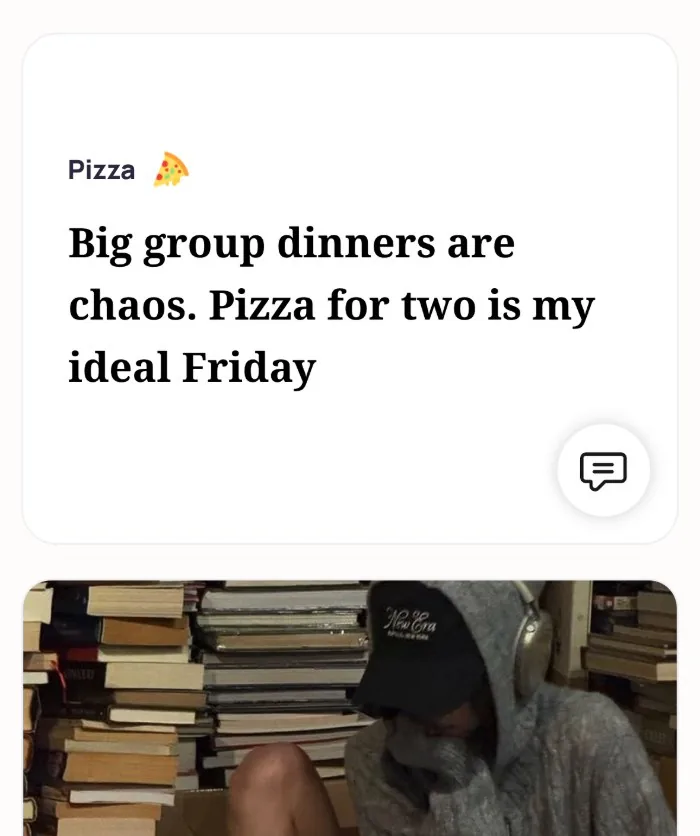 Emma's Alyke interest card for Pizza that reads: Big group dinners are chaos. Pizza for two is my ideal Friday, above her photo in a hoodie and cap among stacks of books