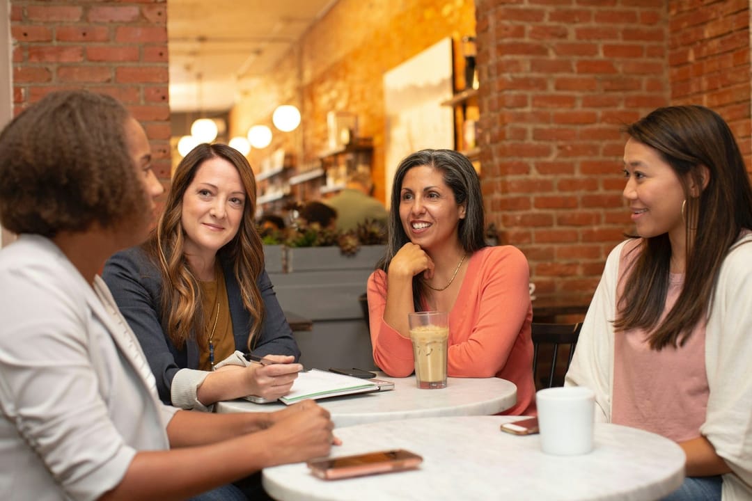 A book club arguing over paperbacks at a bar table