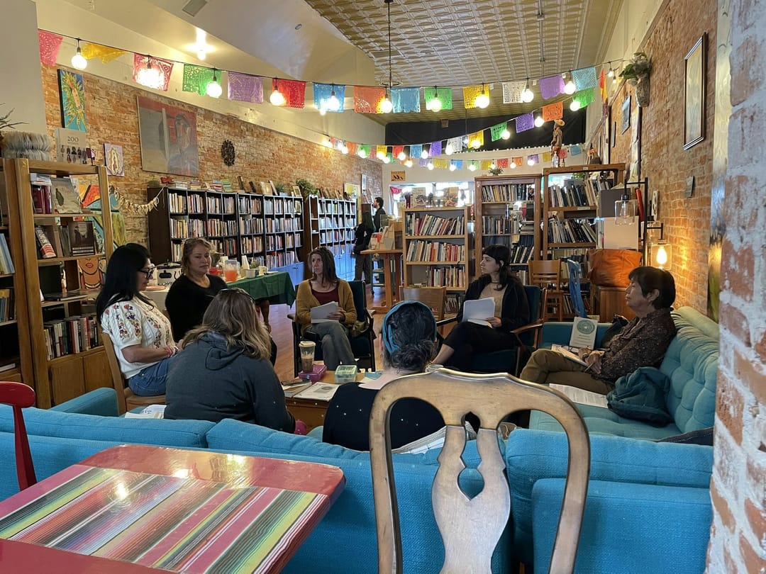 A book club laughing around a bookstore table