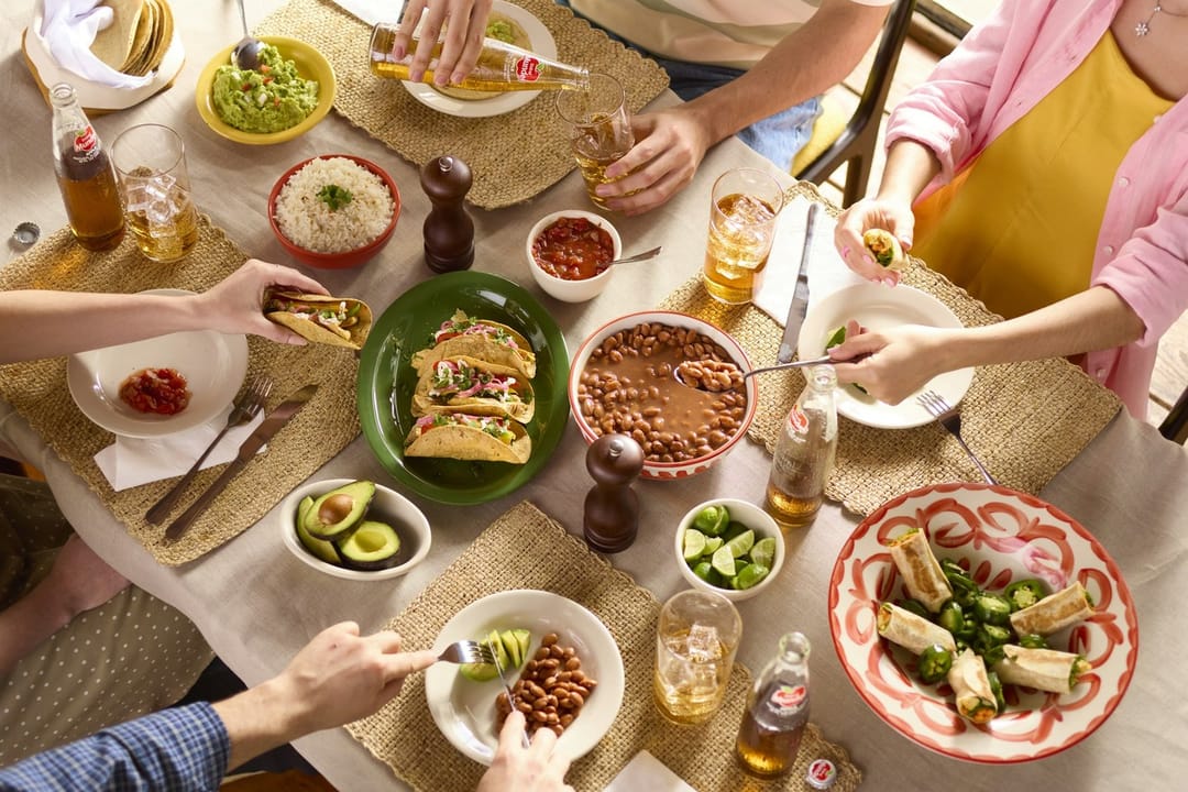 Friends passing dishes around a supper club table