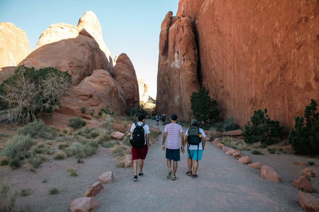 Hikers with headlamps on a desert trail before sunrise
