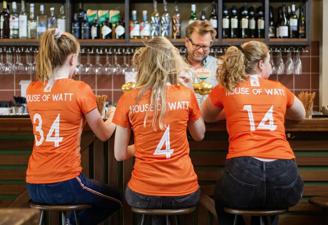 A kickball team at a bar table after a game