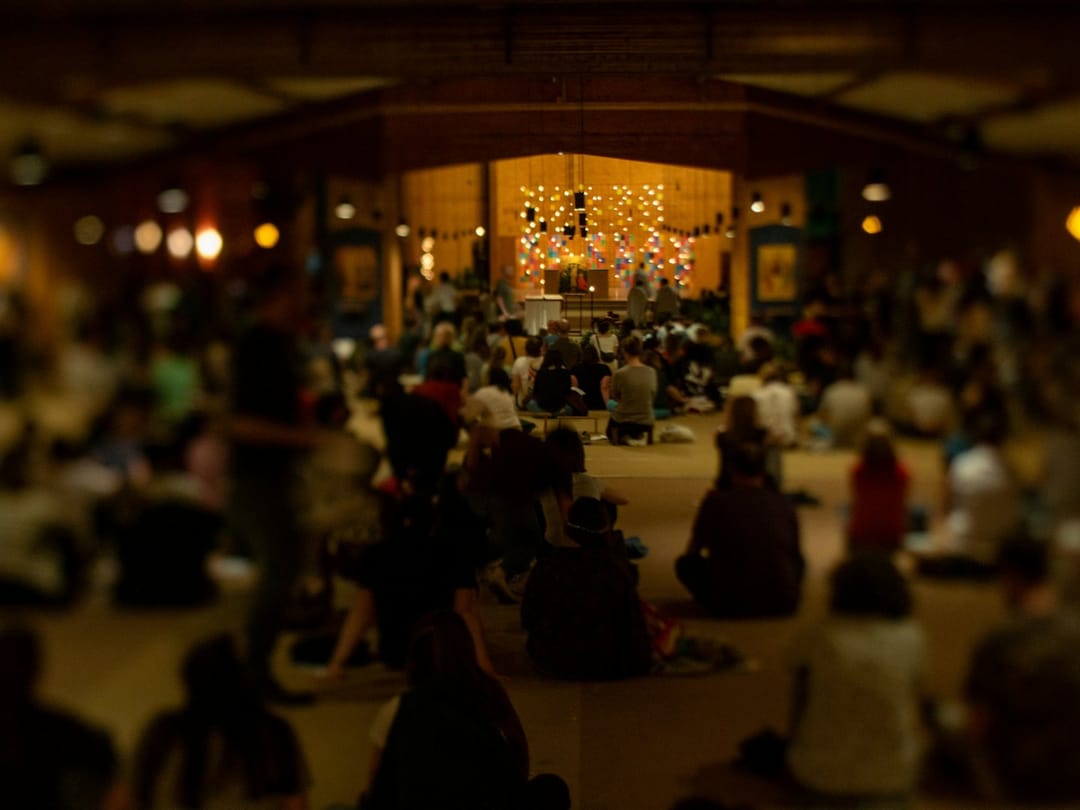 People sitting on the floor at a small living-room concert