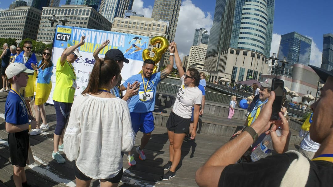 Runners high-fiving at the bottom of memorial steps at dawn