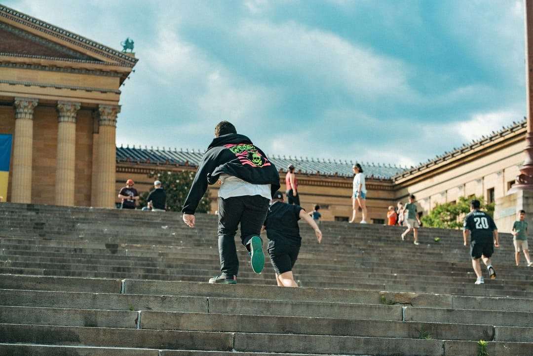 Runners laughing on stadium steps at sunrise