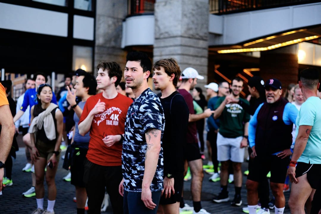 Runners talking on an evening group run between high-rises