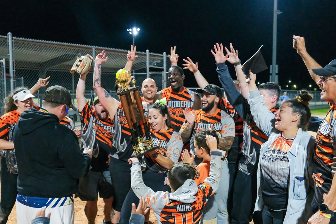 A softball team cheering in the dugout