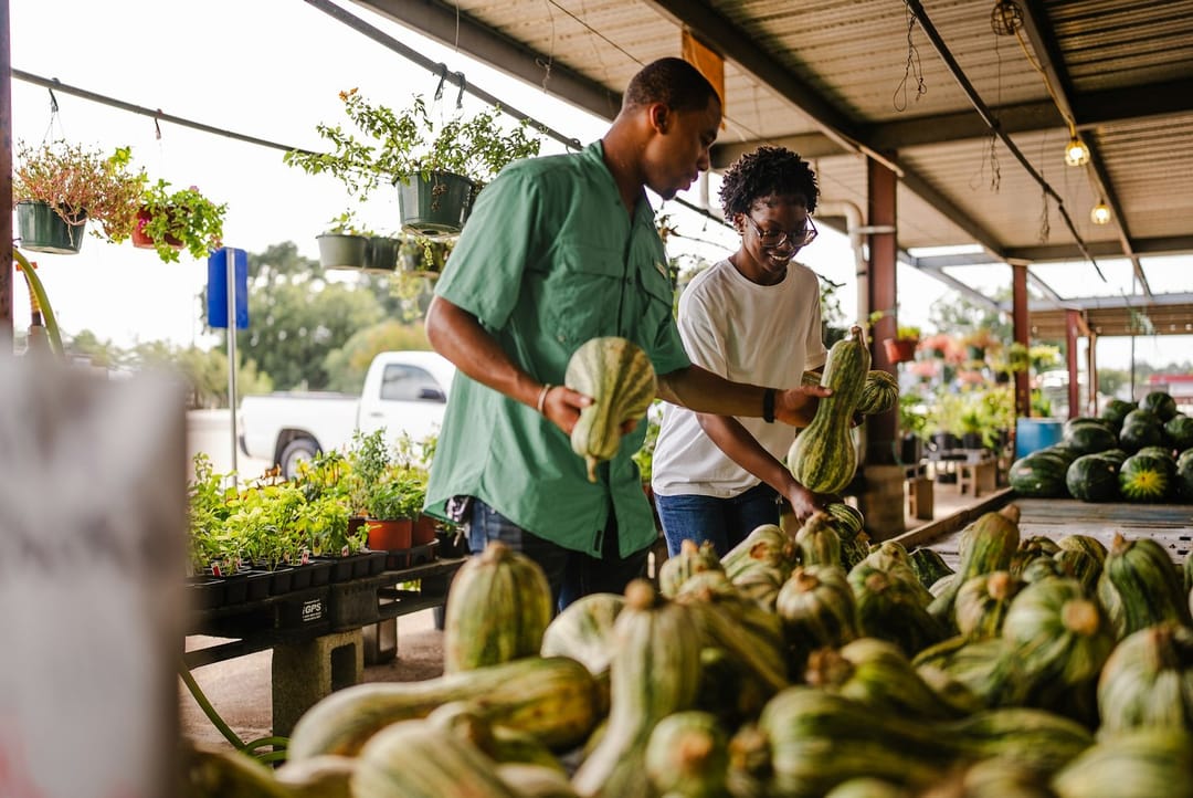 Two friends shopping together at a farmers market on a Saturday morning