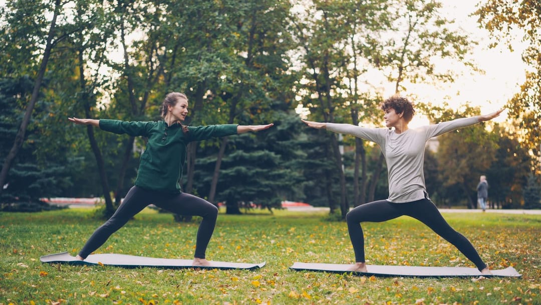 Two people chatting after an evening yoga class in a downtown park