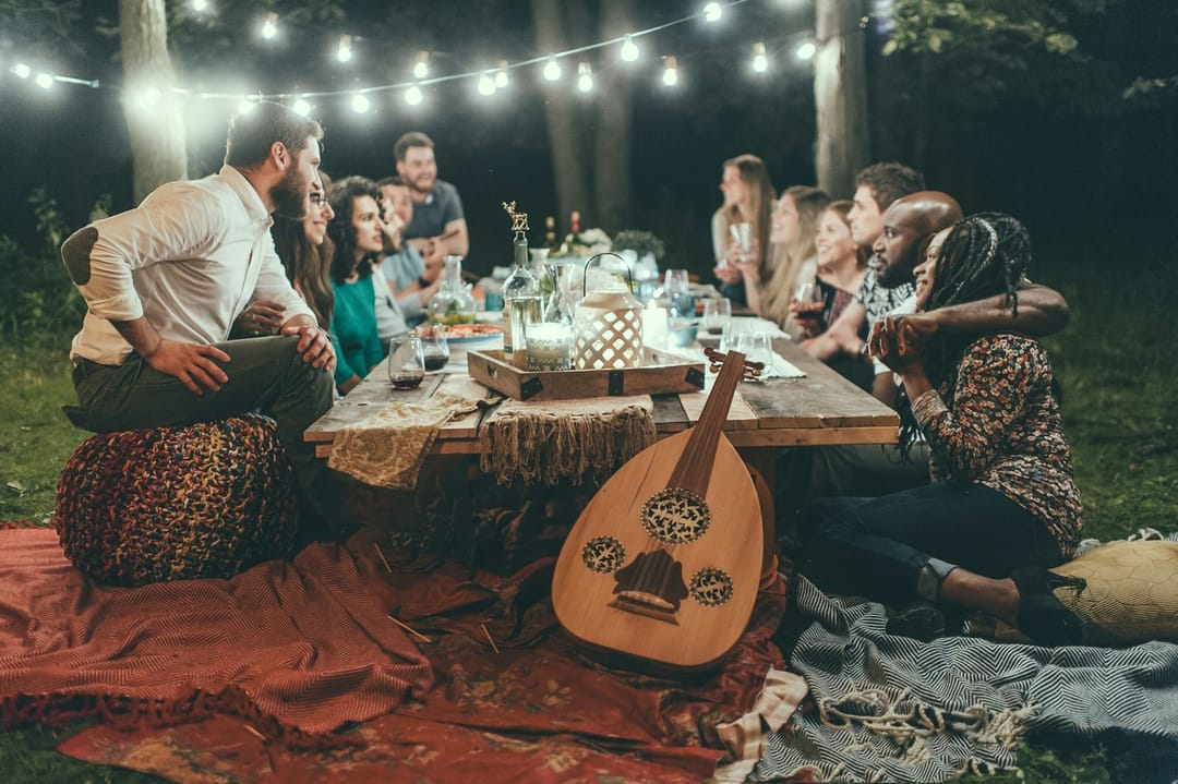 Two people comparing dishes at a backyard potluck