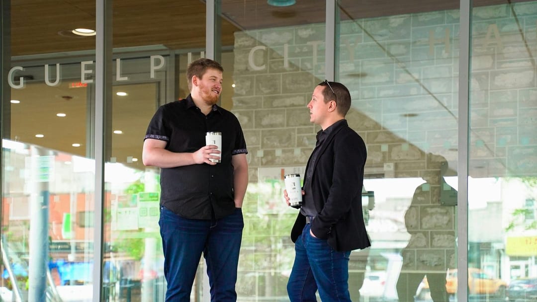 Two people talking over coffee in a church lobby