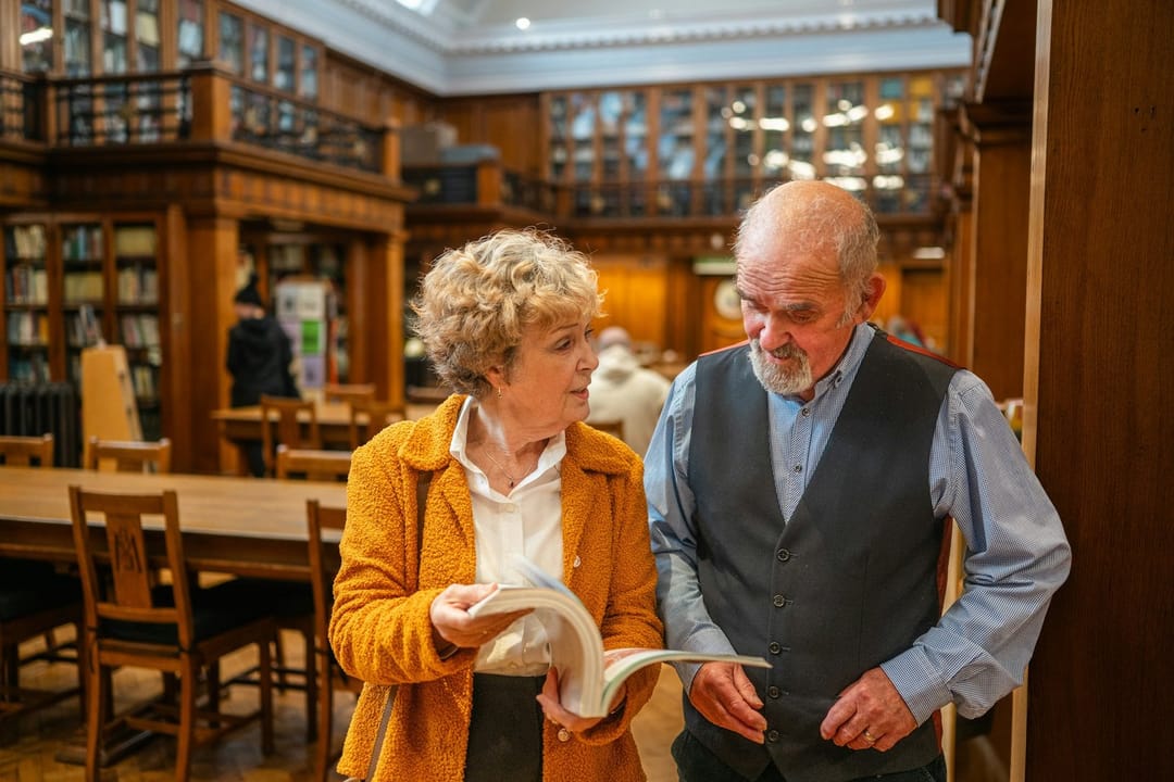 Two people talking in a library lobby after an author talk