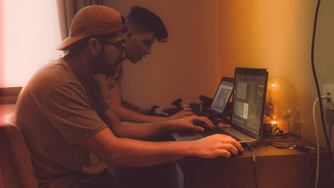 Two people working together on a laptop at a game jam