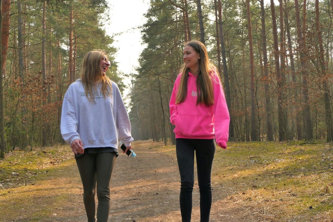 Two runners laughing on a cool-down walk after an early run club