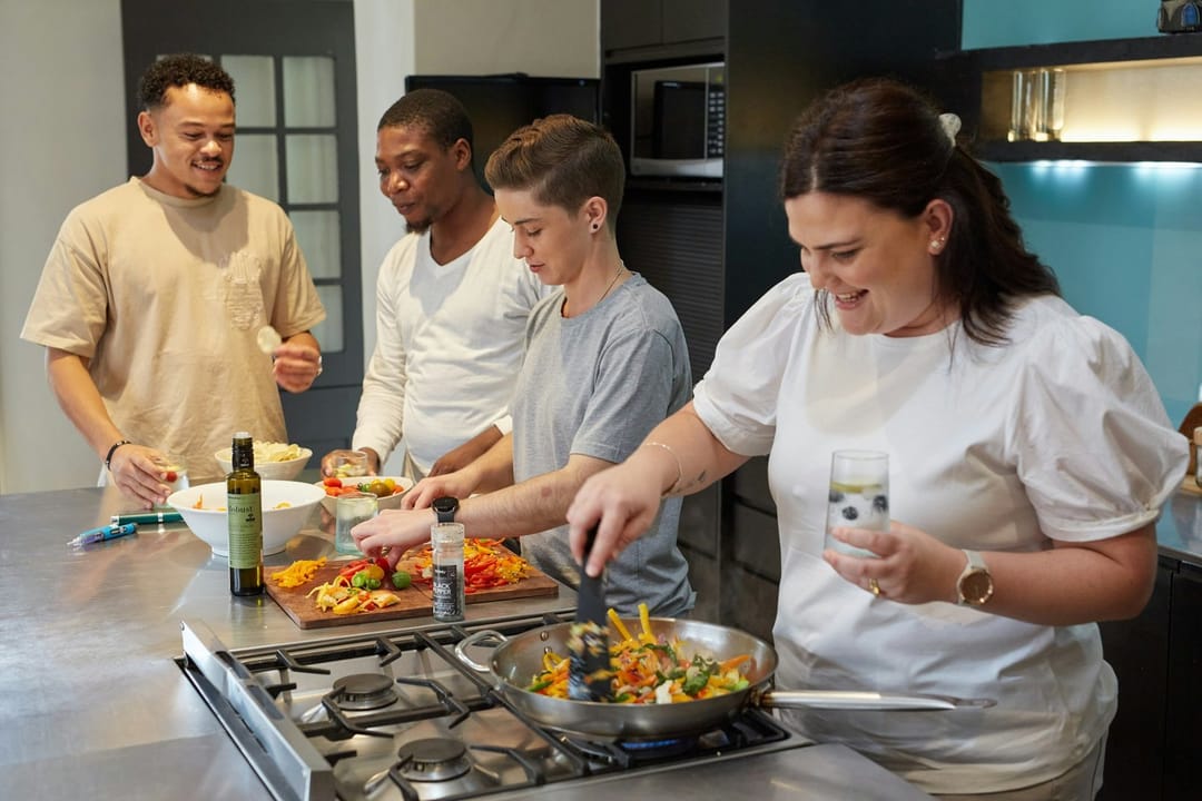 Two students laughing at a shared station in a cooking class