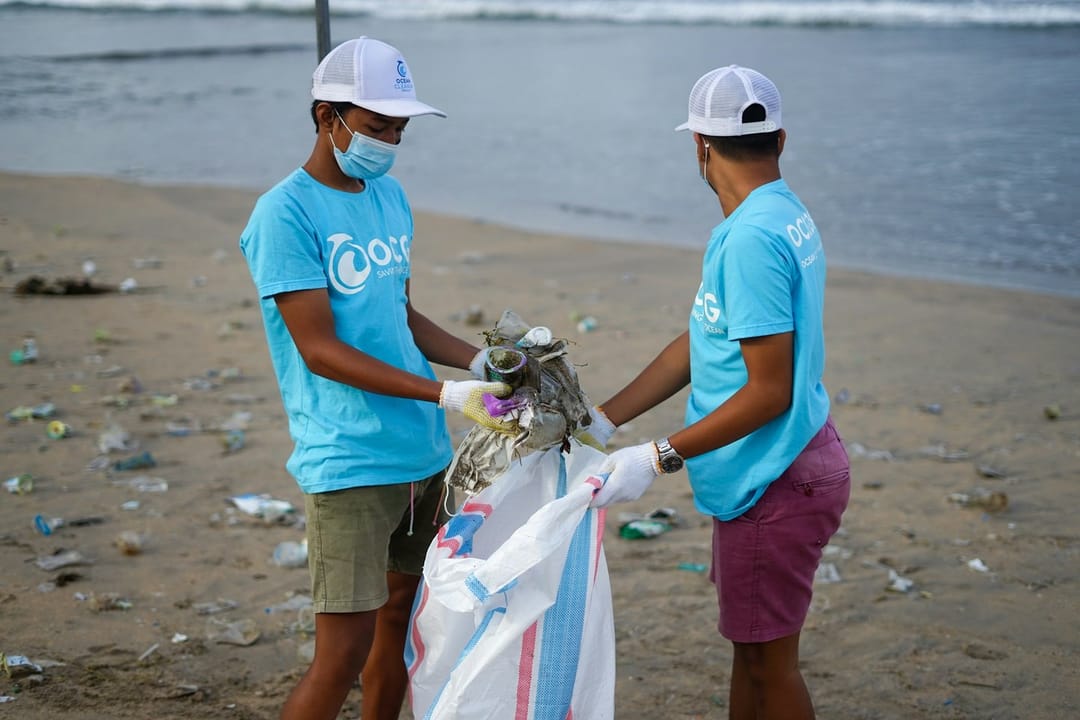 Two volunteers comparing buckets at a beach cleanup