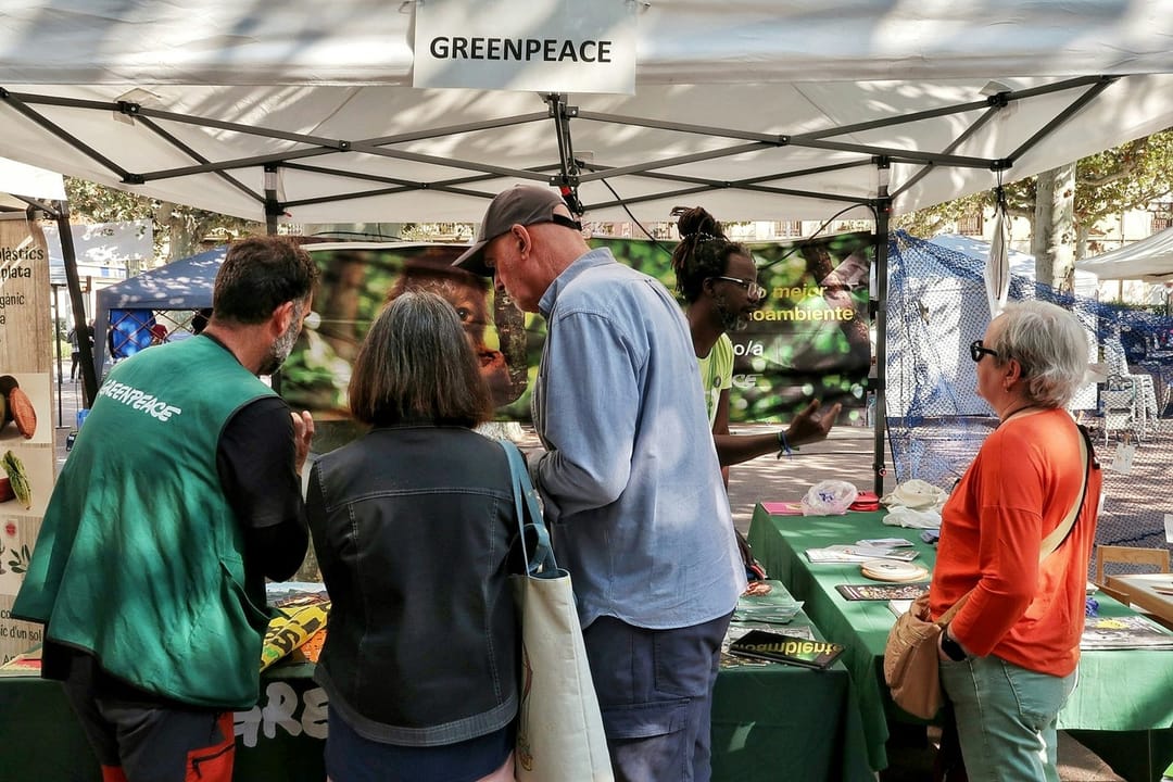 Two volunteers at a sign-up table outside a concert venue