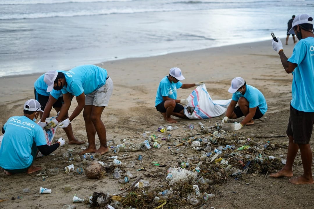 Volunteers laughing during a morning beach cleanup