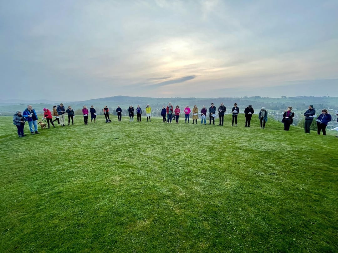 Volunteers and members in a circle before an early morning run
